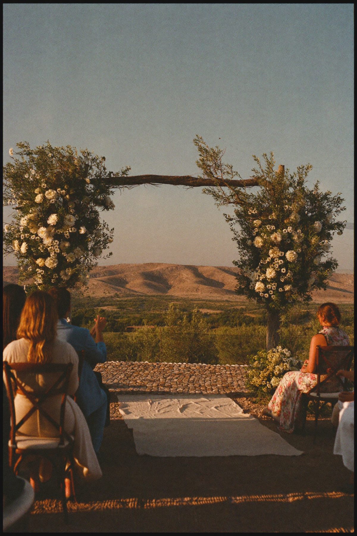 Pareja en ceremonia minimalista, traje sastre, fondo travertino.